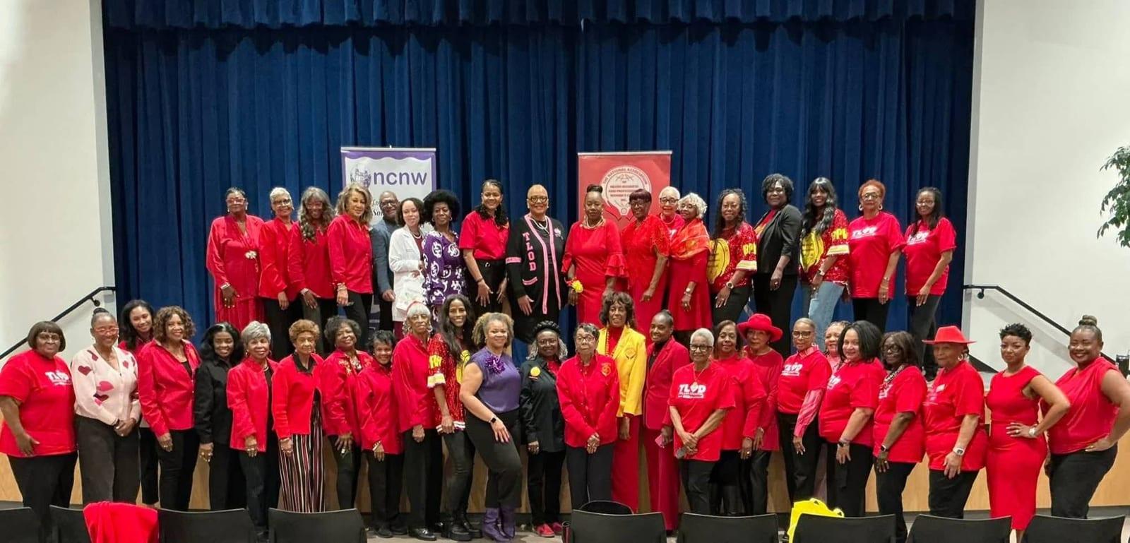 Ladies of the Dallas Chapter, most dressed in red, gathered on stage with partner organizations, including the National Council of Negro Women